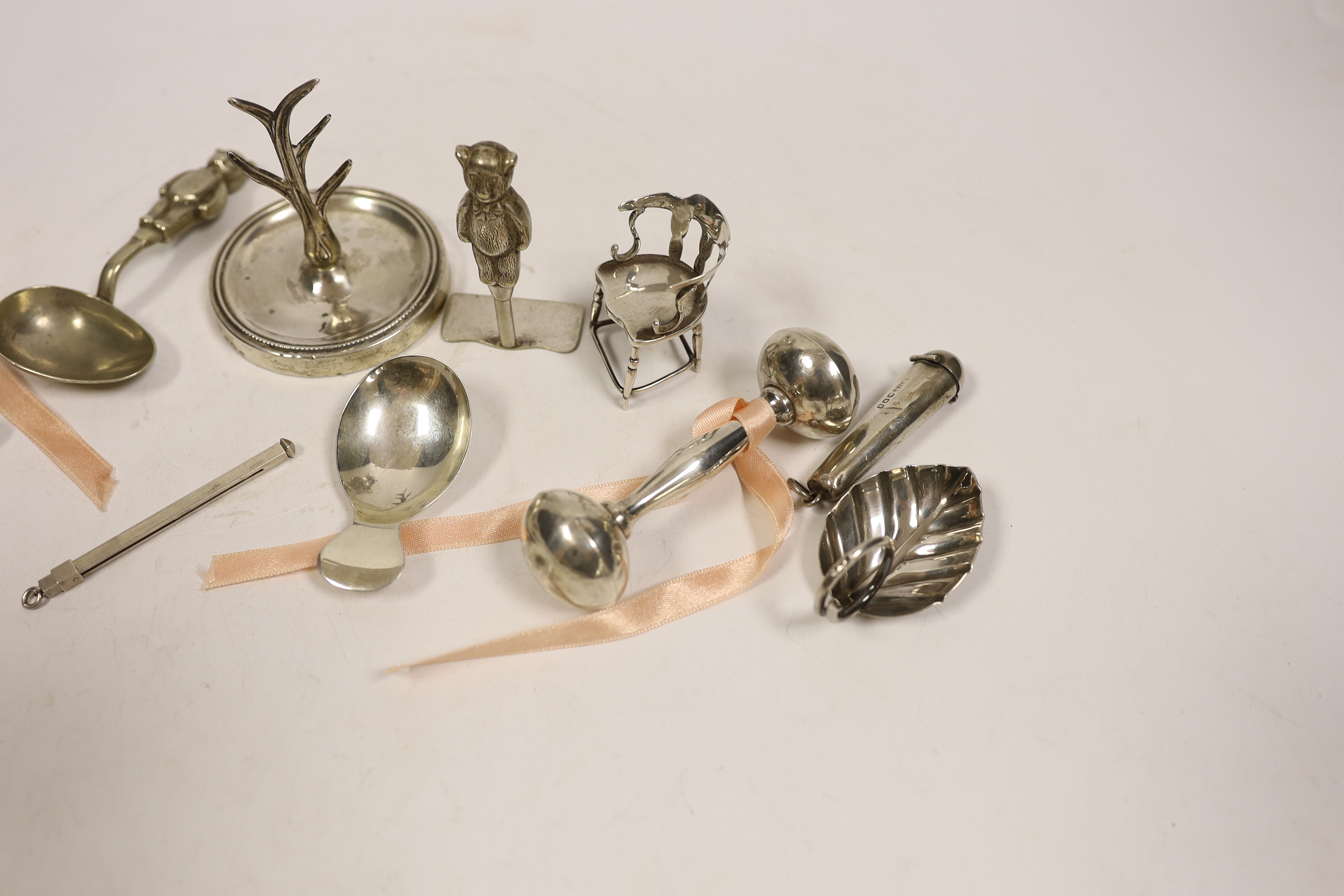 A collection of small silver including an Edwardian silver miniature model 'Dickens 1812-1870' chair, Levy & Salaman, Birmingham, 1910, 46mm, a Georgian silver caddy spoon, a Geoffrey G. Bellamy silver leaf caddy spoon,